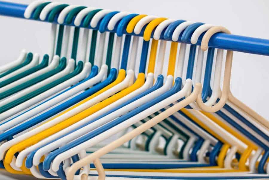 Multi-colored clothes hangers in packed closet