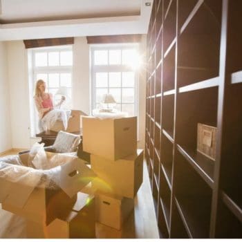 Alt: A woman packing boxes after hiring movers in Dallas TX.