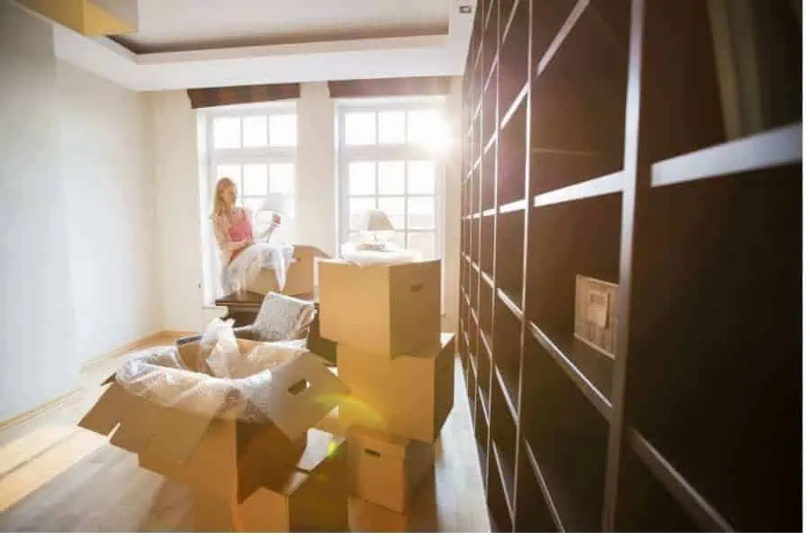 Alt: A woman packing boxes after hiring movers in Dallas TX.