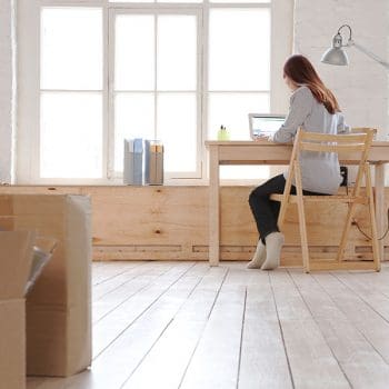 A girl sits at a desk researching Denton TX moving companies.