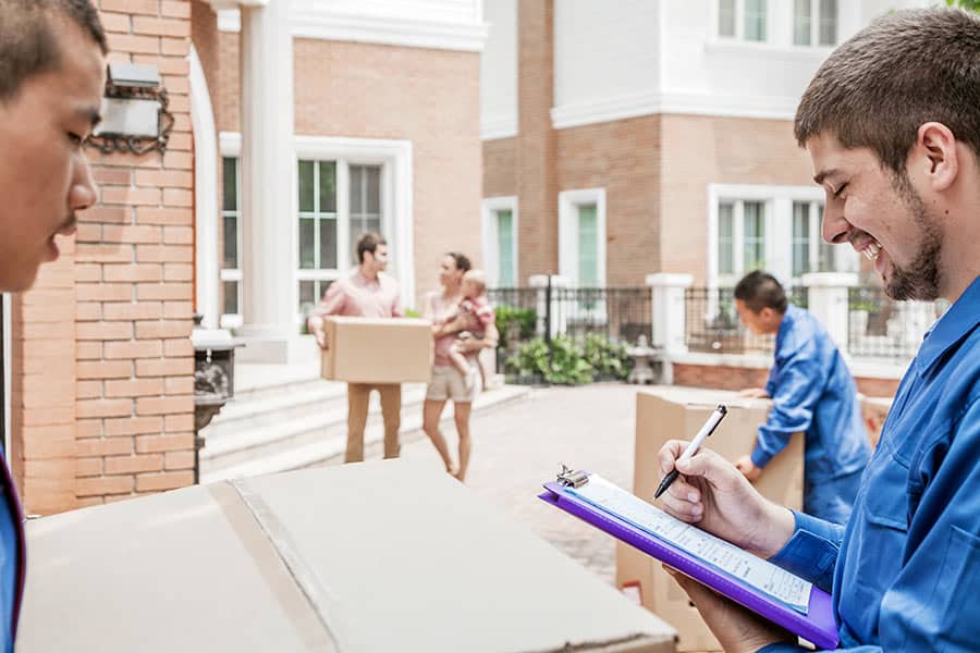 Moving company carrying boxes and invoice