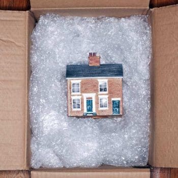 Model of a house in a box padded with bubble wrap, packed by our Southlake TX movers