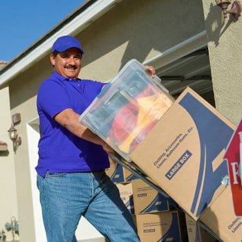 A professional mover loading boxes into a truck using a dolly