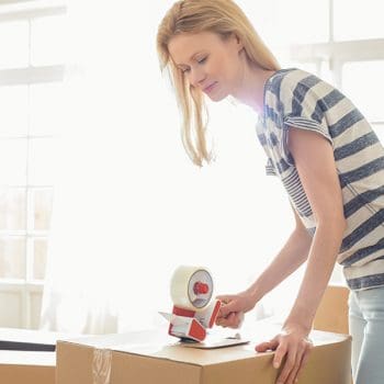Woman Packing Boxes so the movers in Roanoke, Tx can come move them