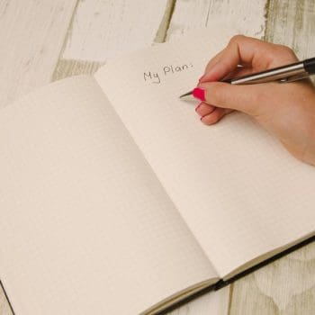Person writing a plan in a notebook to show moving companies in Lewisville