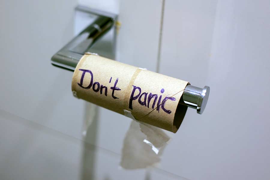 Empty toilet paper roll with the words "don't panic" written - movers in Grapevine, Tx