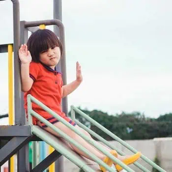 Child sliding on a backyard play set