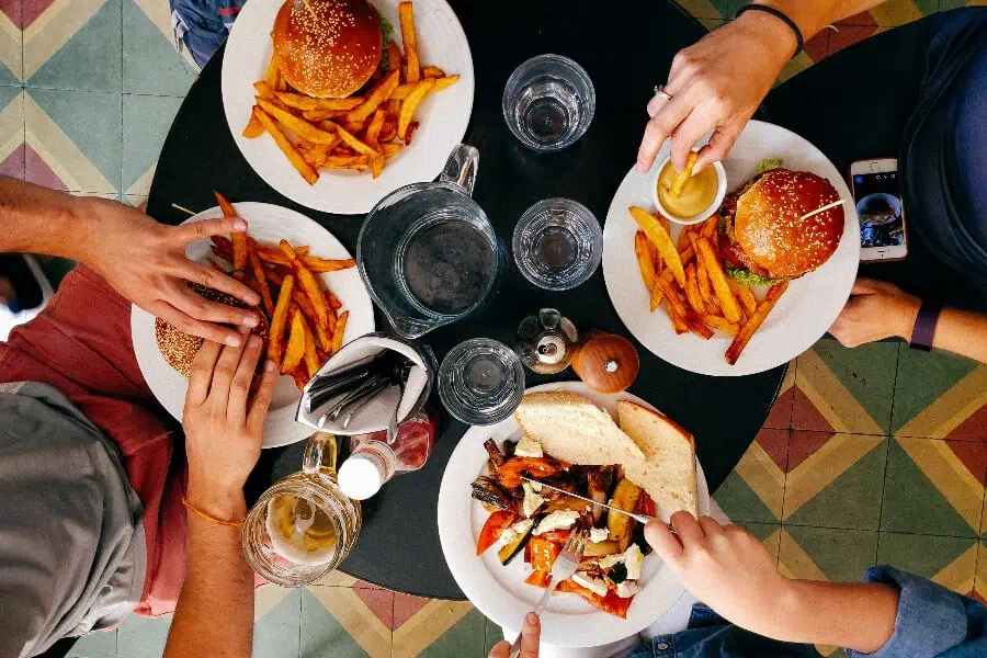 A group of friends enjoying food around a table.