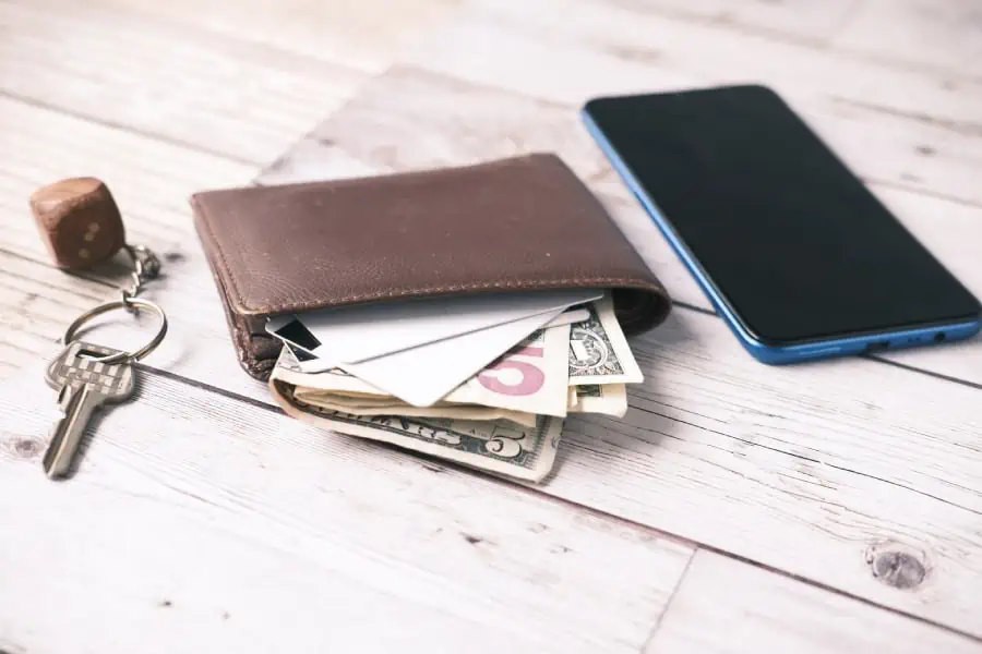 image of keys, wallet and phone all on a wooden backdrop